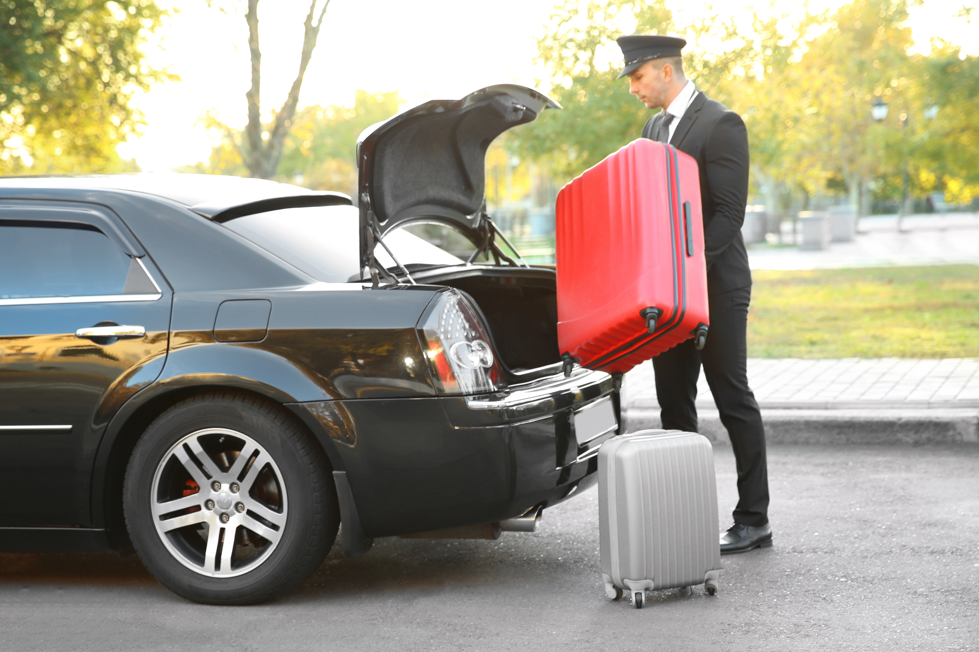 Travel Like a VIP for Your Family Vacation - Chauffeur Placing Luggage in Car