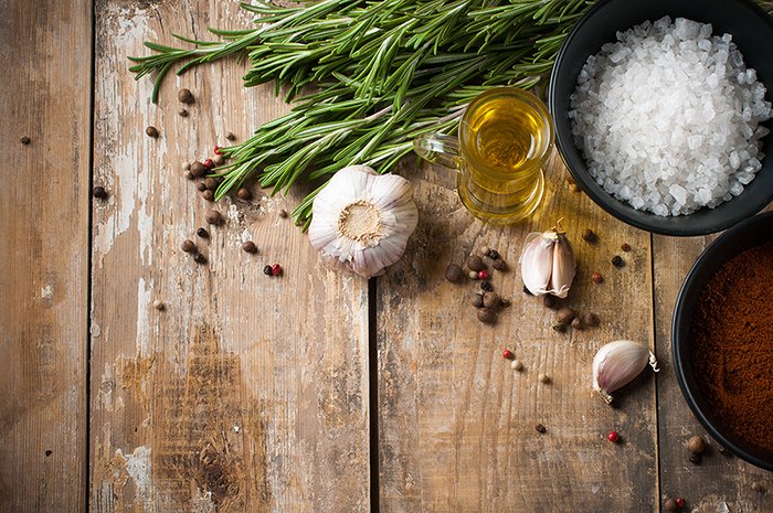 rustic table with garlic, salt, olive oil, and rosemary