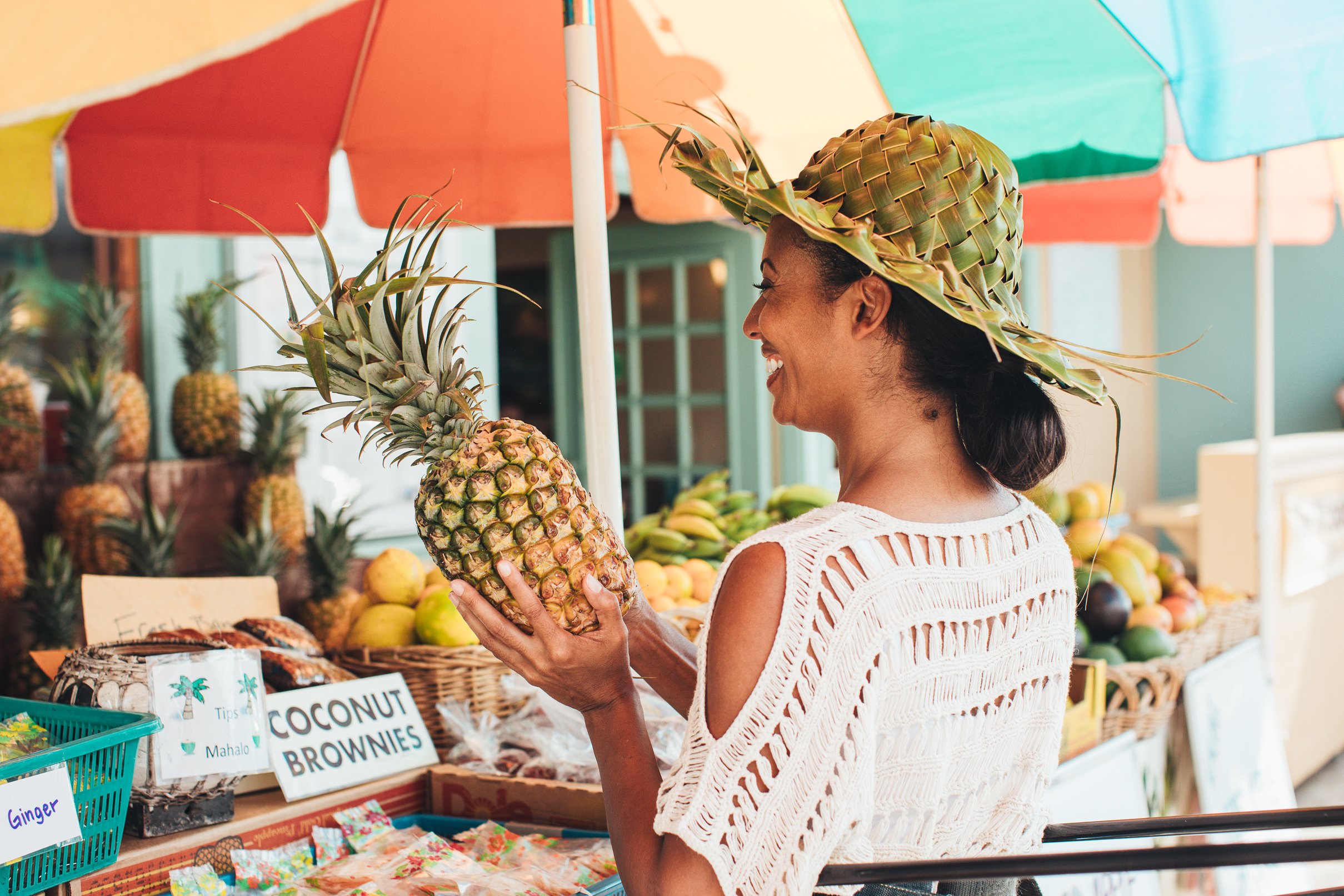 woman purchasing a pineapple from a fruit vendor