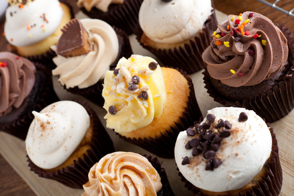 decadent gourmet cupcakes frosted with a variety of frosting flavors.