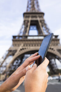 Best Apps for Travel When You're on a Family Vacation - Phone in Front of the Eiffel Tower