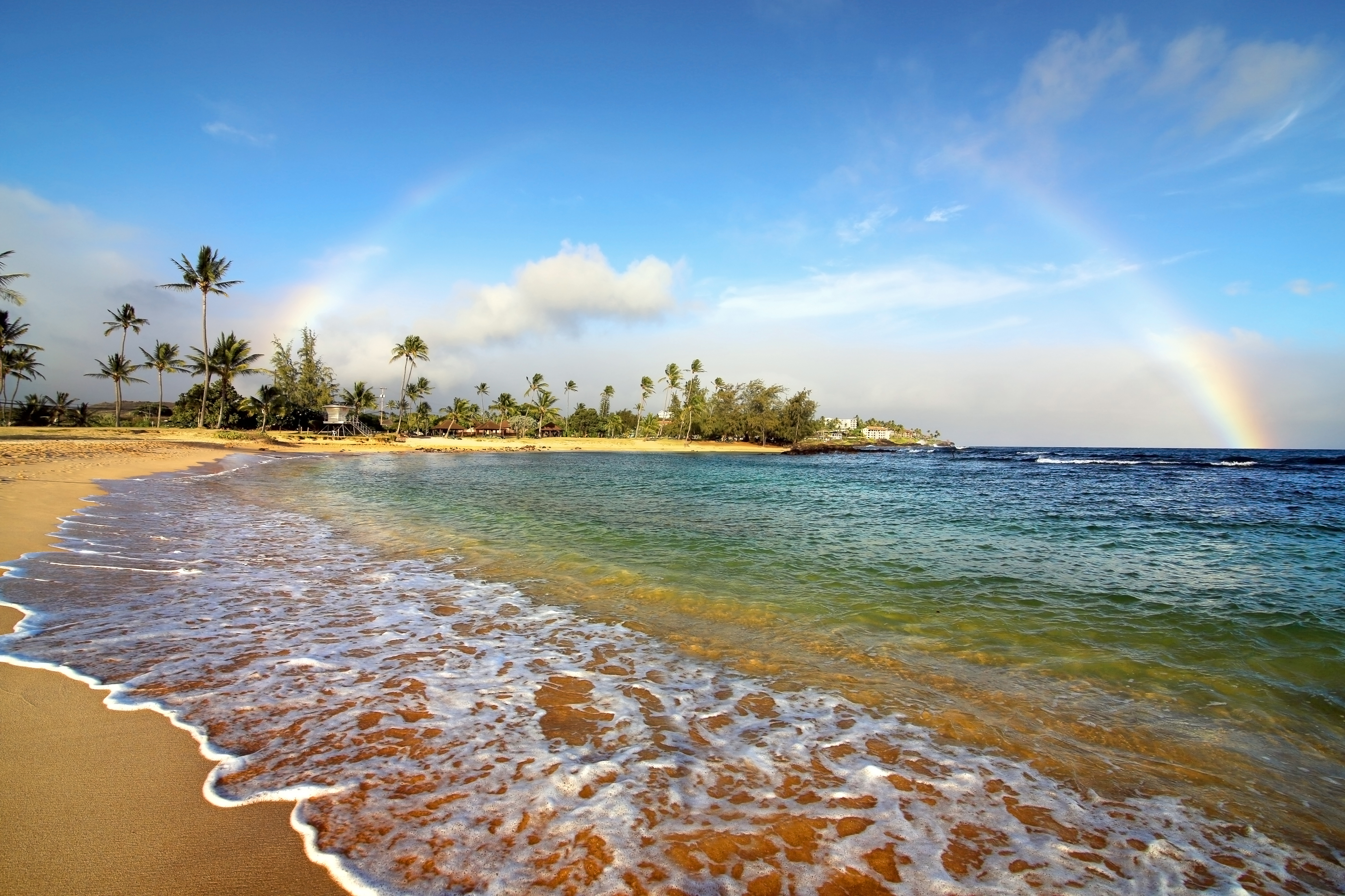 12 Day Spectacular Hawaiian Vacation - Kauai Beach with a rainbow at sunset