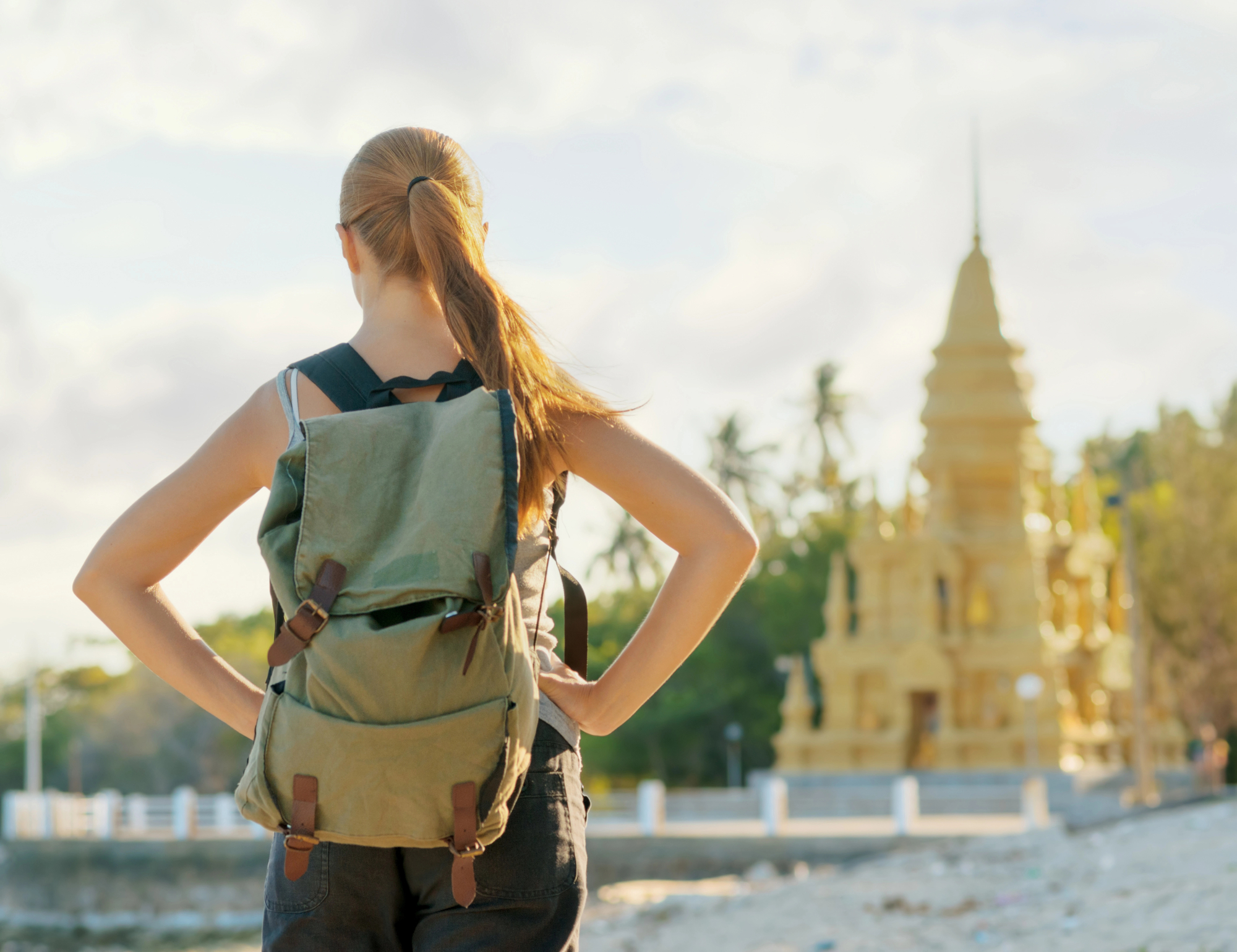 Reasons Solo Female Travelers Should Embrace Vacations - Solo Female Traveler Looking at a Pagoda in Asia