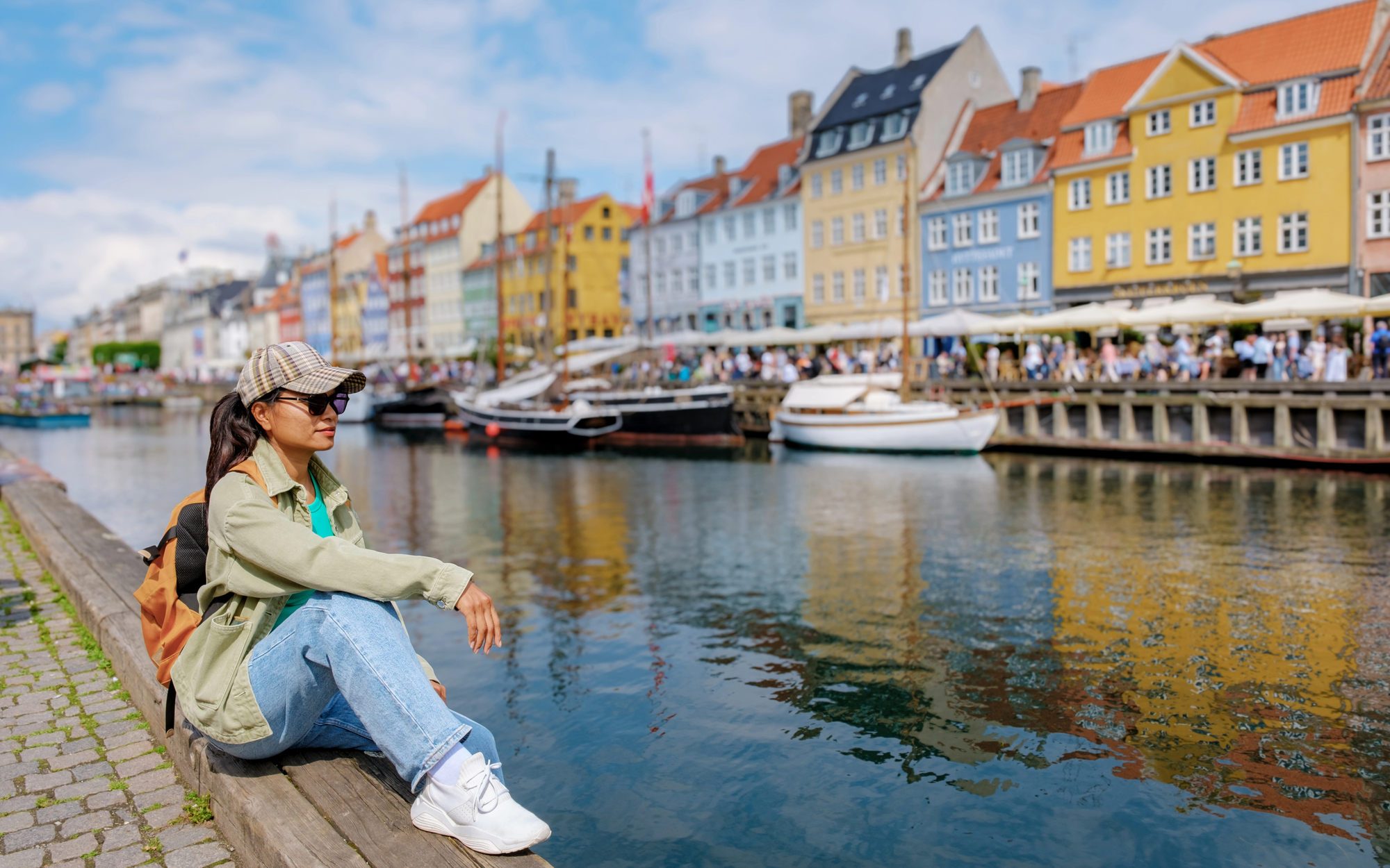 Best Destinations for Solo Female Travelers in Europe - Solo Female Traveler Sitting Near the Canal in Copenhagen, Denmark